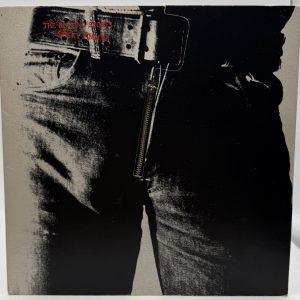 The Rolling Stones Sticky Fingers 1974 vinyl LP playing with working zipper cover displayed